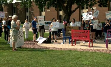 Protesters with signs gather outside the venue for Rep. Bryan Steil's town hall in Elkhorn
