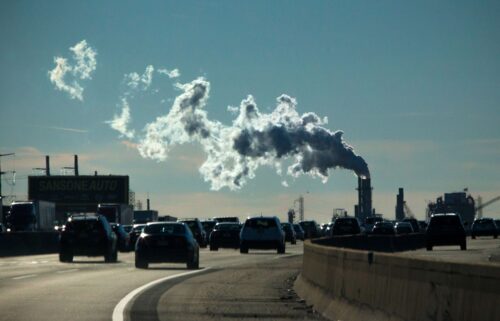 Vehicles move along the The New Jersey Turnpike Way while a Factory emits smoke on November 17