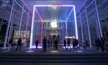 People walk by the Apple Store on Fifth Avenue on February 24 in New York City. Apple is investing another $100 billion to expand its operations in the United States