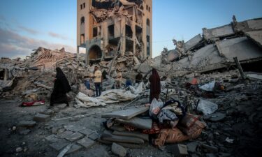 Palestinians make their way through the aftermath of an Israeli strike in the Sheikh Ridwan neighborhood of Gaza City