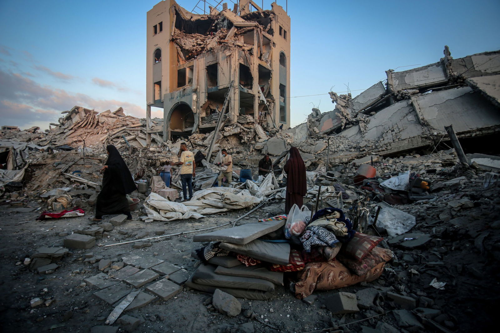 <i>Saeed M. M. T. Jaras/Anadolu/Getty Images via CNN Newsource</i><br/>Palestinians make their way through the aftermath of an Israeli strike in the Sheikh Ridwan neighborhood of Gaza City