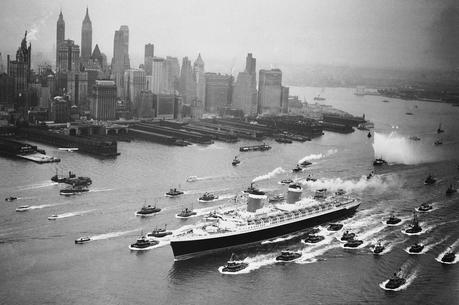 <i>Bettmann Archive/Getty Images via CNN Newsource</i><br/>A huge cordon of tugs accompanies the SS United States past the New York skyline on June 23