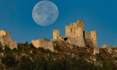 The full sturgeon moon appears in the sky over Rocca Calascio Castle in Calascio