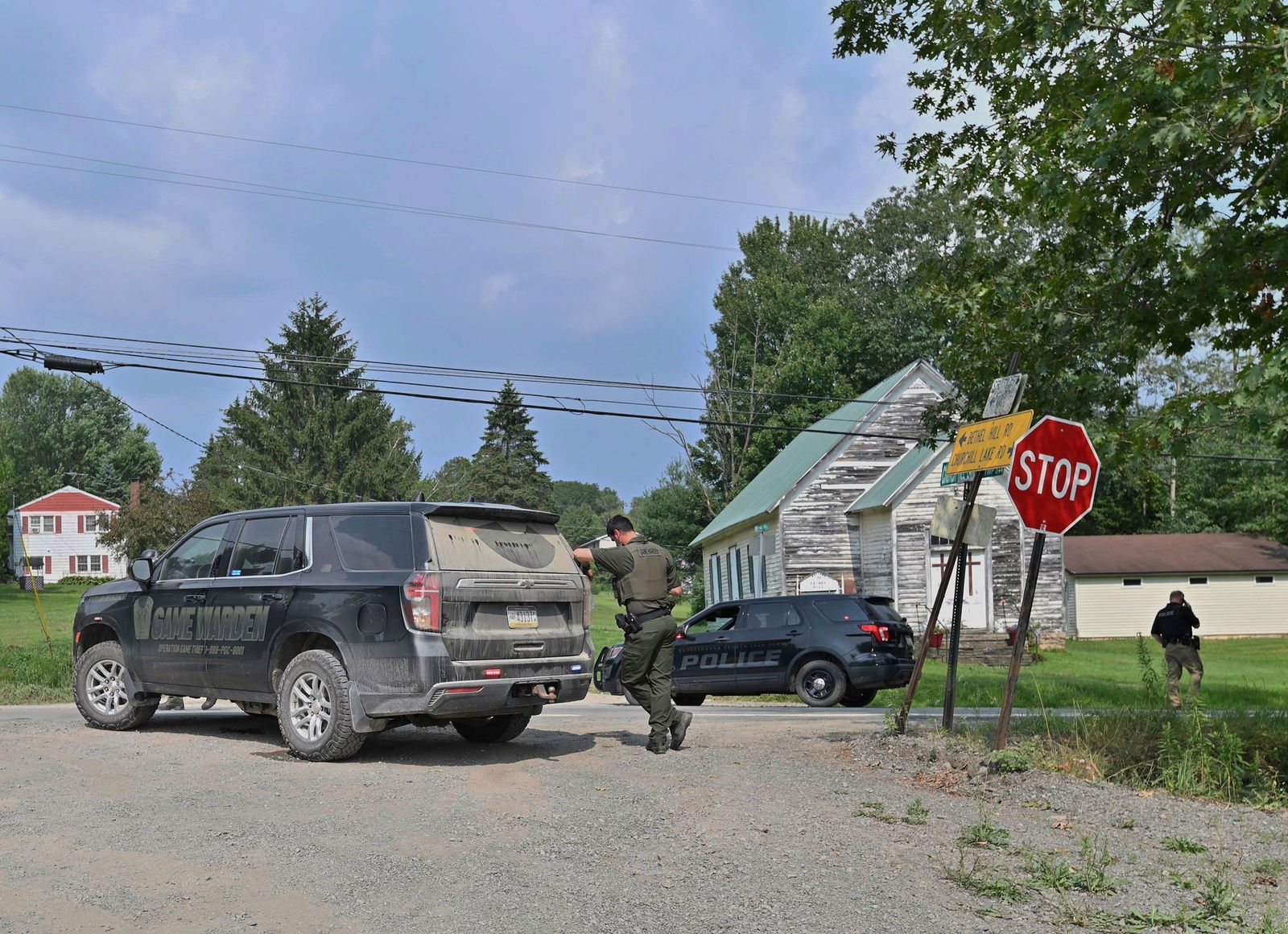 <i>Aimee Dilger/AP via CNN Newsource</i><br/>Police officers block the street leading to where two Pennsylvania state troopers were shot on August 7