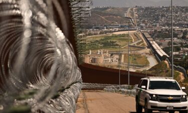 A US Customs and Border Protection (CBP) Border Patrol vehicle drives past recently installed concertina wire along the US-Mexico border between San Diego and Tijuana in San Diego