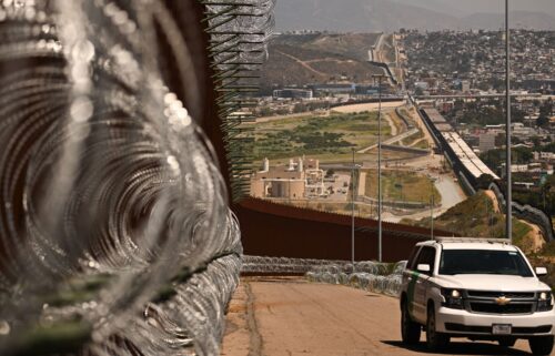 A US Customs and Border Protection (CBP) Border Patrol vehicle drives past recently installed concertina wire along the US-Mexico border between San Diego and Tijuana in San Diego