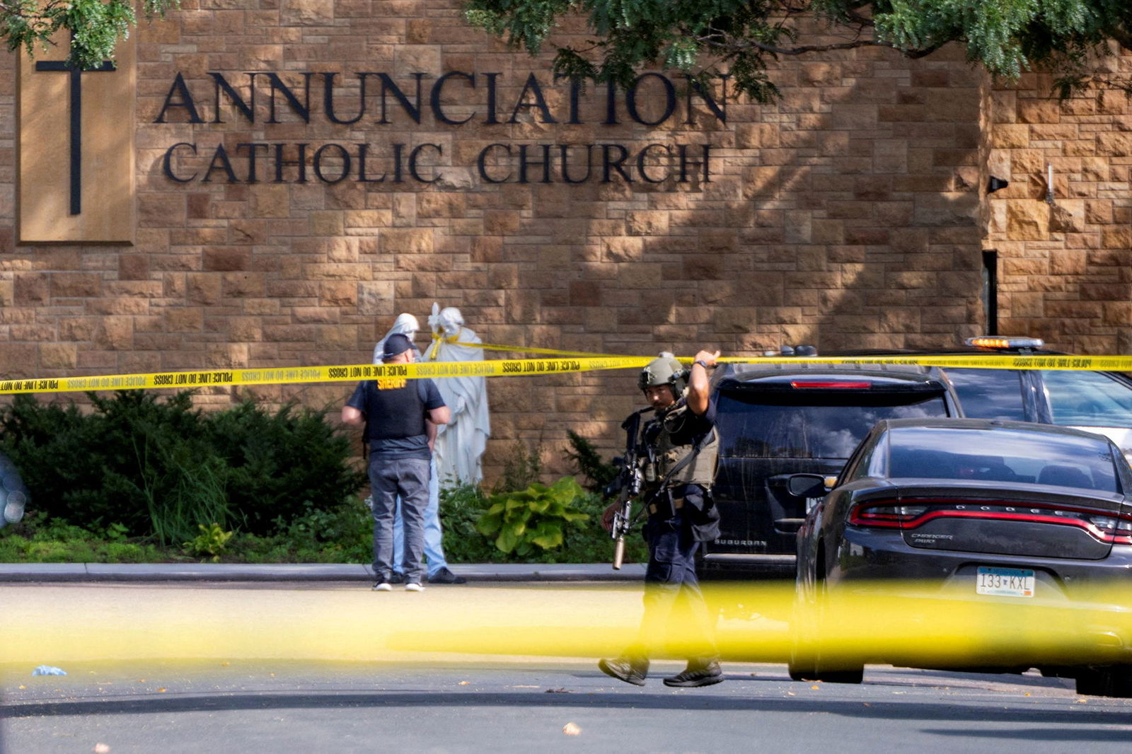Law enforcement officers set up barriers after a shooting at Annunciation Church in Minneapolis on Wednesday.