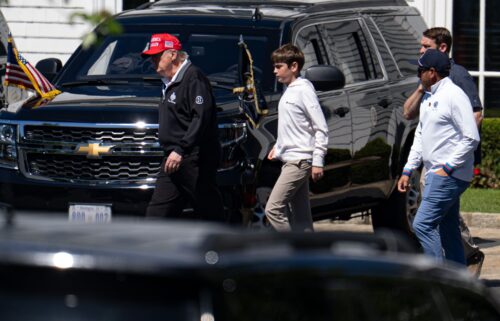 President Donald Trump walks with his grandchild Spencer Trump after golfing at Trump National Golf Club in Sterling