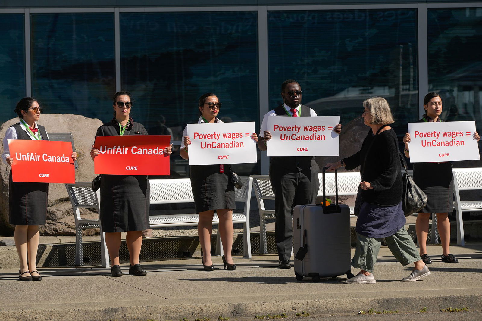 <i>Liang Sen/Xinhua/Getty Images via CNN Newsource</i><br/>Air Canada flight attendants standing in a silent protest at Vancouver International Airport.