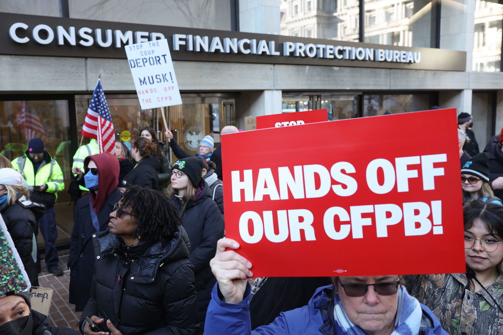<i>Jemal Countess/Getty Images for MoveOn/File via CNN Newsource</i><br/>Demonstrators raise signs and posters during a rally outside the Consumer Financial Protection Bureau headquarters in Washington