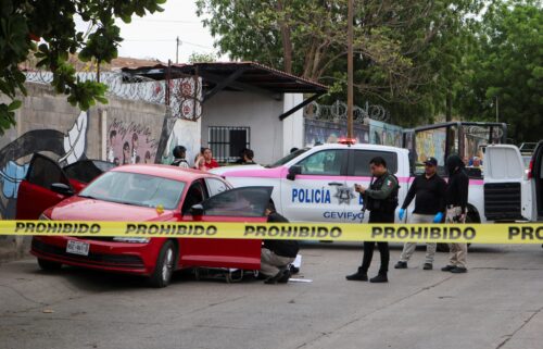 Police officers work a crime scene where a man was gunned down in Culiacán