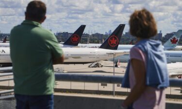 Travelers look out over grounded Air Canada planes as flight attendants picket at Pearson International Airport in Toronto on August 18