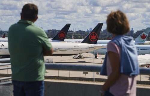 Travelers look out over grounded Air Canada planes as flight attendants picket at Pearson International Airport in Toronto on August 18