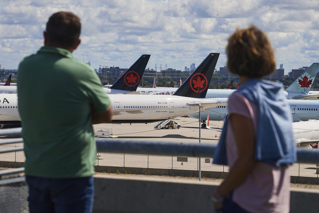 <i>Sammy Kogan/AP via CNN Newsource</i><br/>Travelers look out over grounded Air Canada planes as flight attendants picket at Pearson International Airport in Toronto on August 18