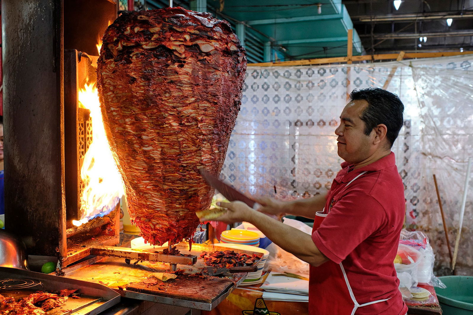 <i>Jorge Fernández/LightRocket/Getty Images via CNN Newsource</i><br/>A server cuts from a large spit of meat that's roasting in a food stand in the municipal market in Mérida