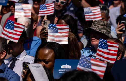 New US citizens use handheld fans to take shade from the sun during a naturalization ceremony at George Washington's Mount Vernon in Virginia