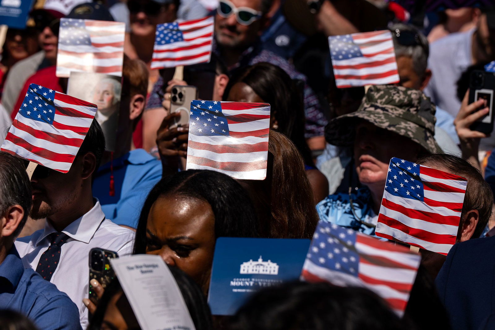 <i>Kent Nishimura/Bloomberg/Getty Images/File via CNN Newsource</i><br/>New US citizens use handheld fans to take shade from the sun during a naturalization ceremony at George Washington's Mount Vernon in Virginia
