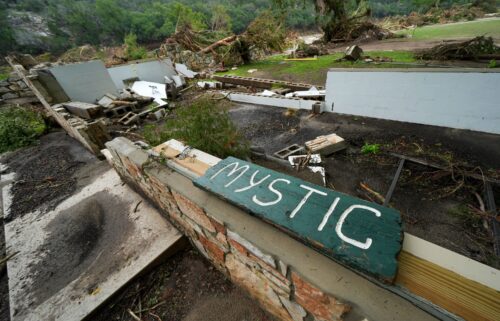 A Camp Mystic sign is seen along the banks of the Guadalupe River in Hunt