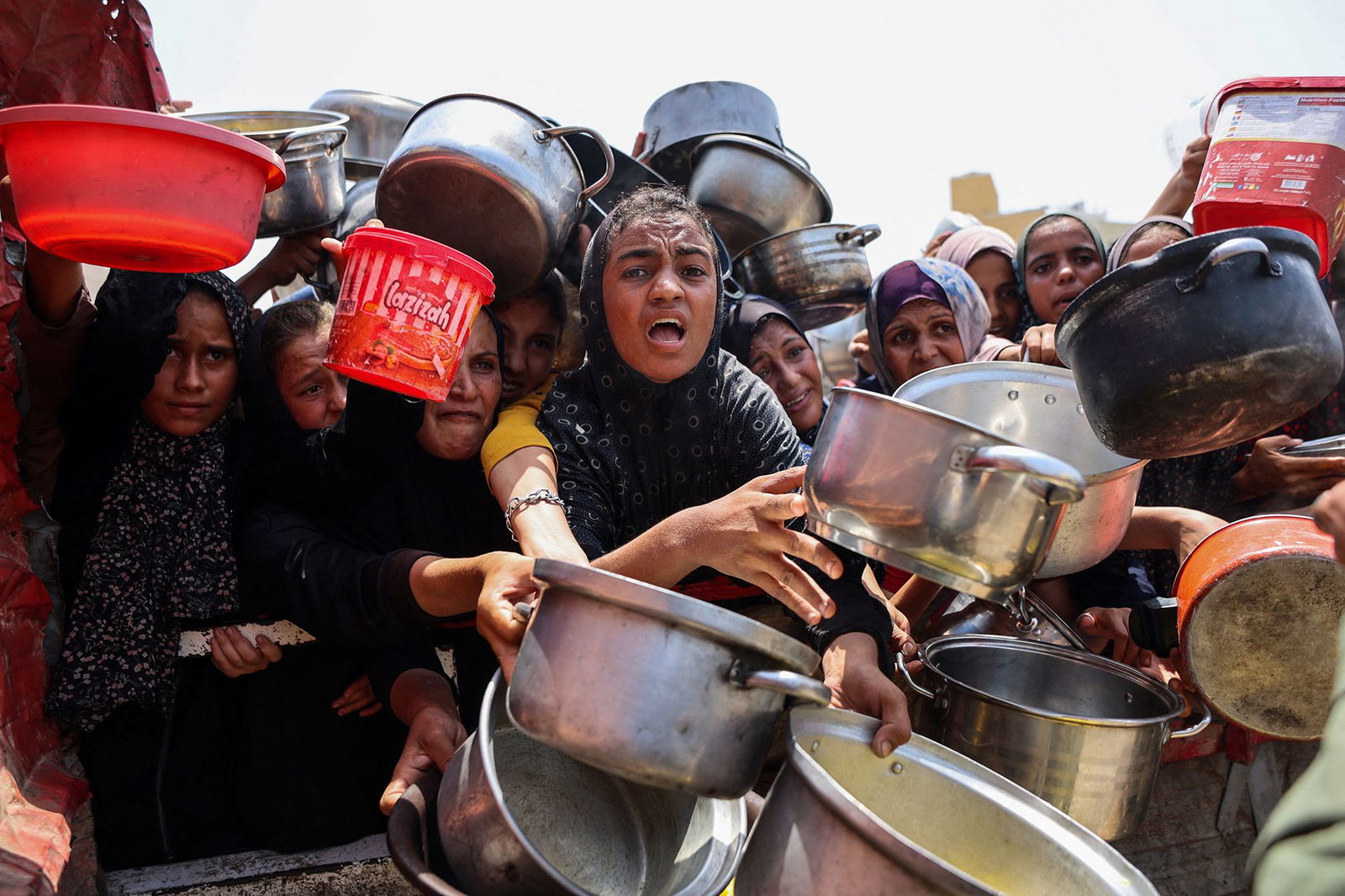 <i>Omar Al-Qattaa/AFP/Getty Images via CNN Newsource</i><br/>Palestinians gather to receive cooked meals from a food distribution center in Gaza City on August 13