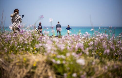 Visitors take photos near Hamdeok Beach in Jeju City. The island of Jeju has issued a multi-language guide warning international visitors to behave following a string of viral tourist incidents and cases of disorderly conduct.