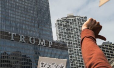 Protesters give a thumbs down gesture while marching past Trump Tower in Chicago