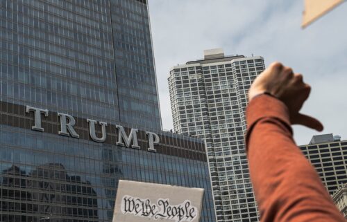 Protesters give a thumbs down gesture while marching past Trump Tower in Chicago