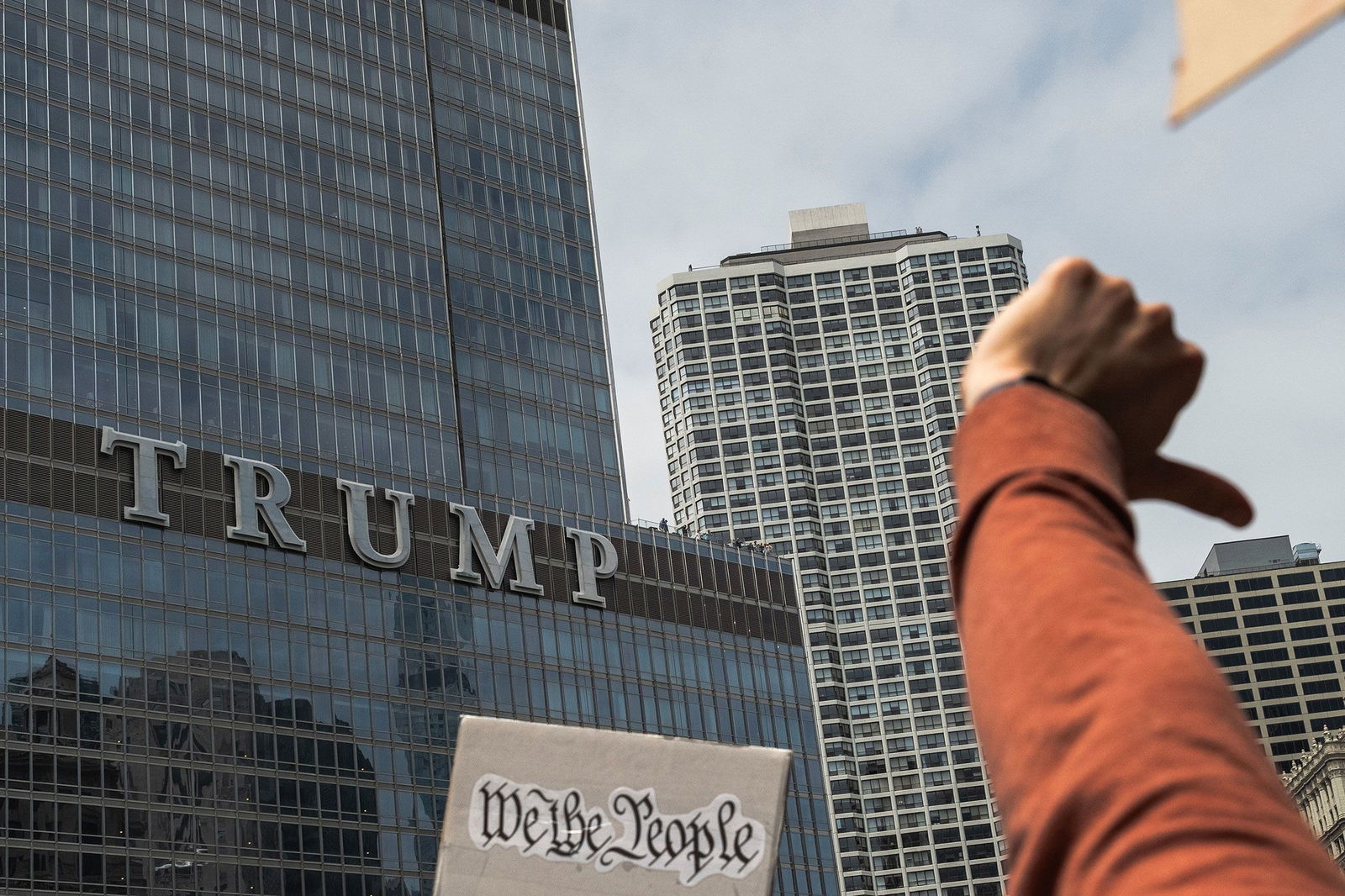 <i>Jim Vondruska/Getty Images via CNN Newsource</i><br/>Protesters give a thumbs down gesture while marching past Trump Tower in Chicago