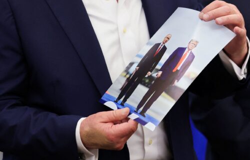 US President Donald Trump holds an image of him and Russian President Vladimir Putin