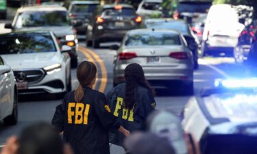 FBI members walk outside the home of the former White House national security adviser John Bolton as it is searched by FBI on Friday in Bethesda