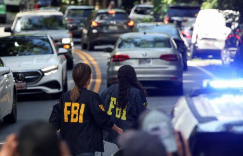 FBI members walk outside the home of the former White House national security adviser John Bolton as it is searched by FBI on Friday in Bethesda
