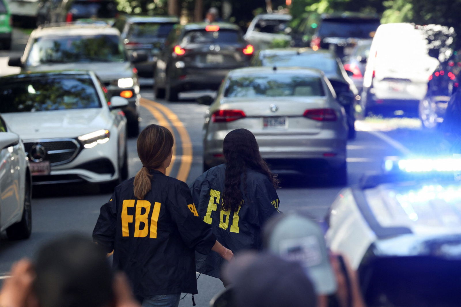 <i>Tasos Katopodis/Reuters via CNN Newsource</i><br/>FBI members walk outside the home of the former White House national security adviser John Bolton as it is searched by FBI on Friday in Bethesda