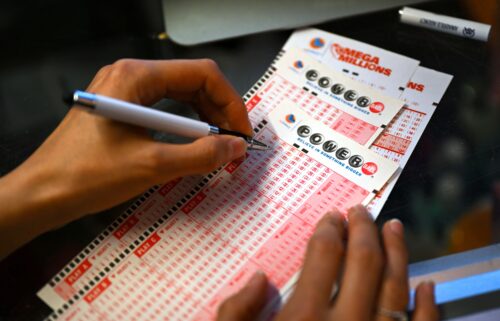 A person plays the lottery at a store as the US Powerball jackpot grand prize grew to a whopping $1 billion after no ticket got all six numbers in San Mateo