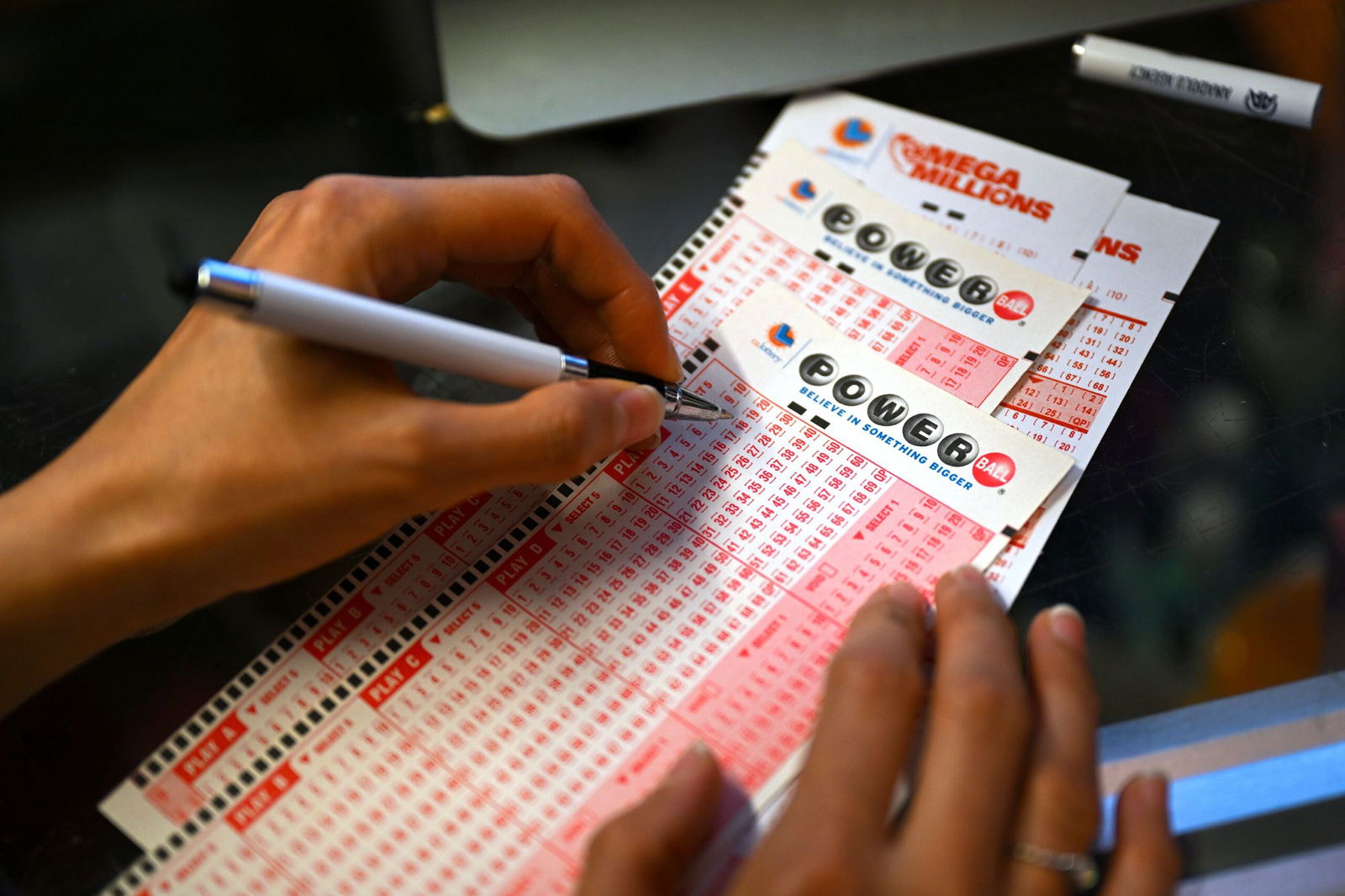 <i>Tayfun Coskun/Anadolu Agency/Getty Images via CNN Newsource</i><br/>A person plays the lottery at a store as the US Powerball jackpot grand prize grew to a whopping $1 billion after no ticket got all six numbers in San Mateo