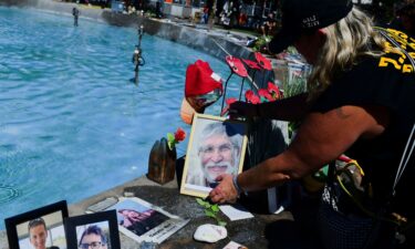 A woman places a picture of slain Israeli hostage Yoram Metzger on October 7 at a fountain in Tel Aviv which has become an unofficial memorial for hostages