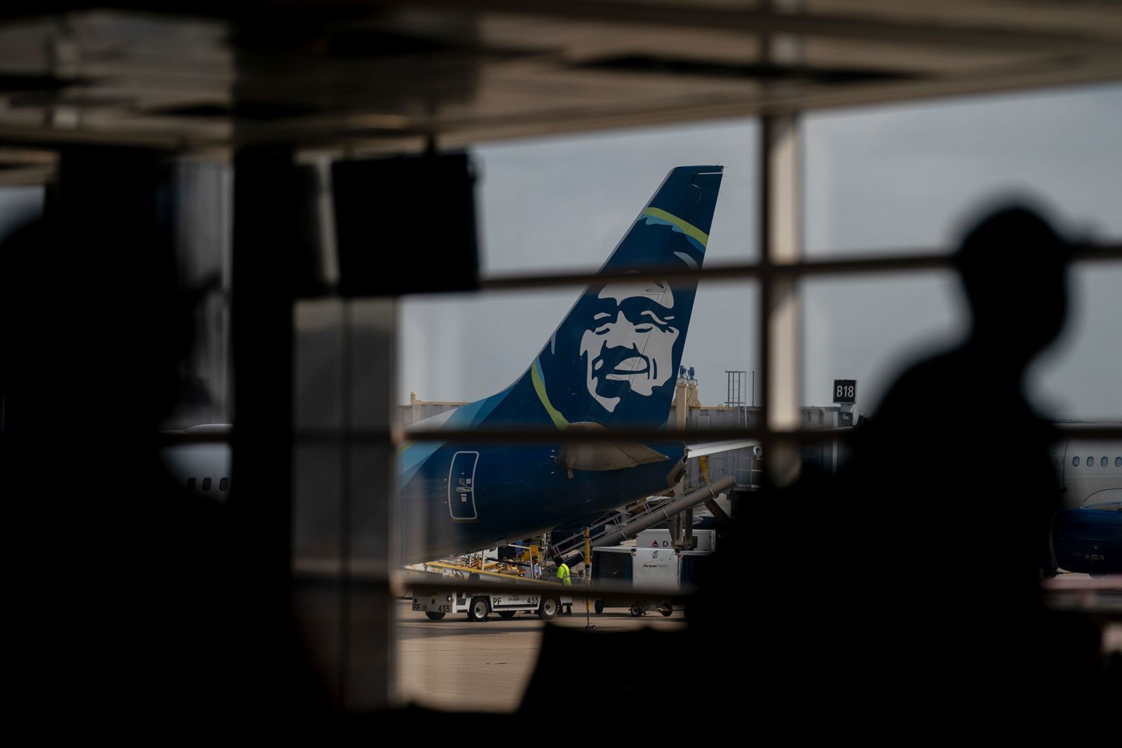 <i>Stefani Reynolds/Bloomberg/Getty Images via CNN Newsource</i><br/>An Alaska Airlines plane past travelers at Ronald Reagan Washington National Airport in Arlington