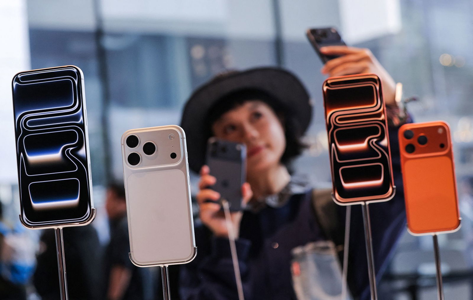 <i>Maxim Shemetov/Reuters via CNN Newsource</i><br/>A woman takes a selfie with iPhones inside the Apple store in Beijing's Sanlitun area as the new iPhone 17 series smartphones go on sale in Beijing