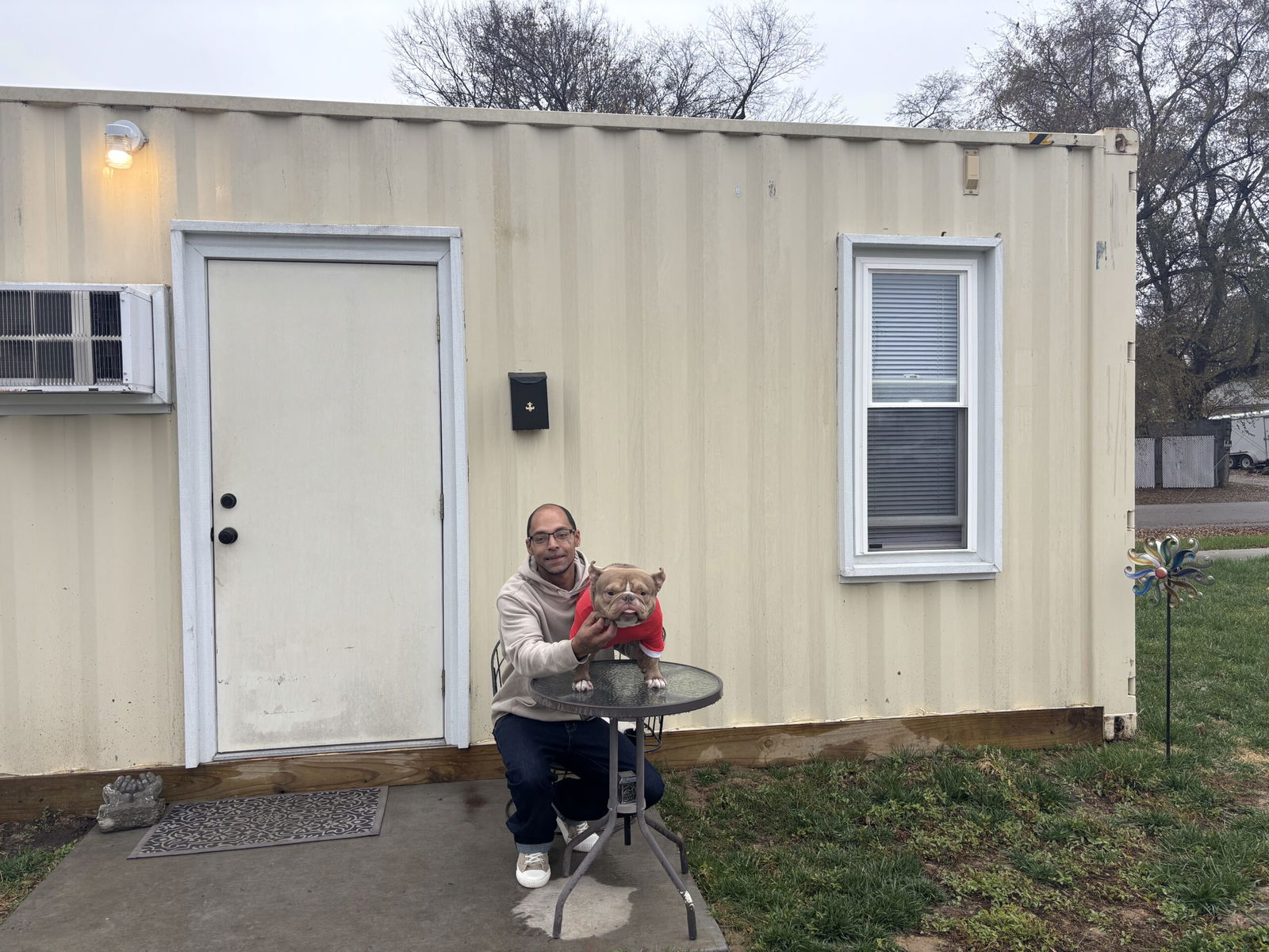 LaRon Thompson, a Tiny Homes Village resident with his dog, Queso.