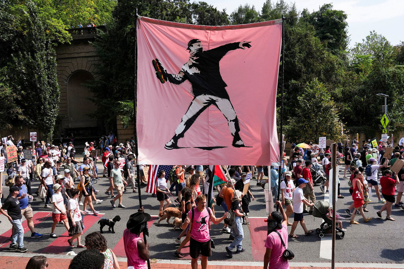 <i>Leah Millis/Reuters/File via CNN Newsource</i><br/>Demonstrators hold a banner in the style of the artist Banksy