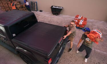Volunteers help load a vehicle during a food distribution targeting federal employees and SNAP recipients in October in San Antonio.
