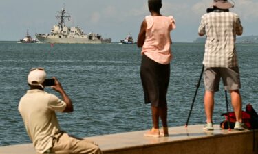 People watch the USS Gravely depart the Port of Spain in Trinidad and Tobago on October 30. The warship arrived in Trinidad and Tobago on October 26