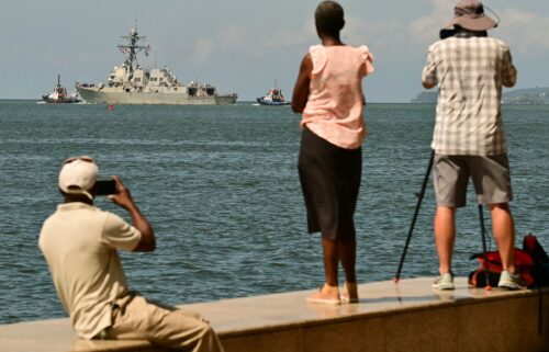 People watch the USS Gravely depart the Port of Spain in Trinidad and Tobago on October 30. The warship arrived in Trinidad and Tobago on October 26