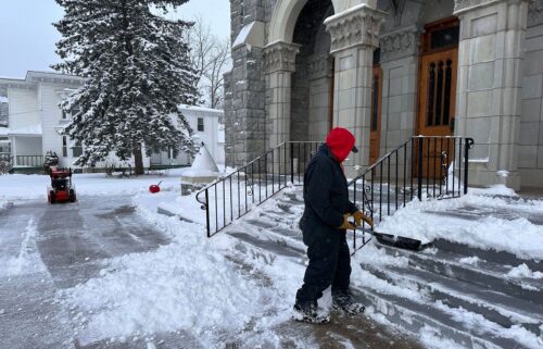 A man shovels snow outside a church in Lowville