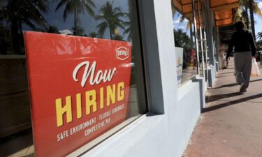 A 'Now Hiring' sign sits in the window of a Denny's restaurant on November 19 in Miami.